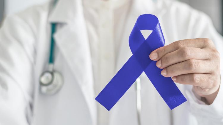 Doctor holding colorectal cancer awareness ribbon