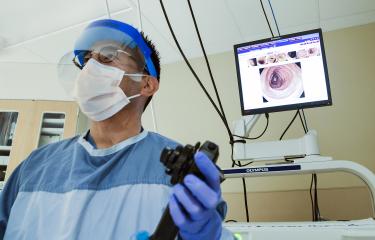 Physician with mask doing procedure
